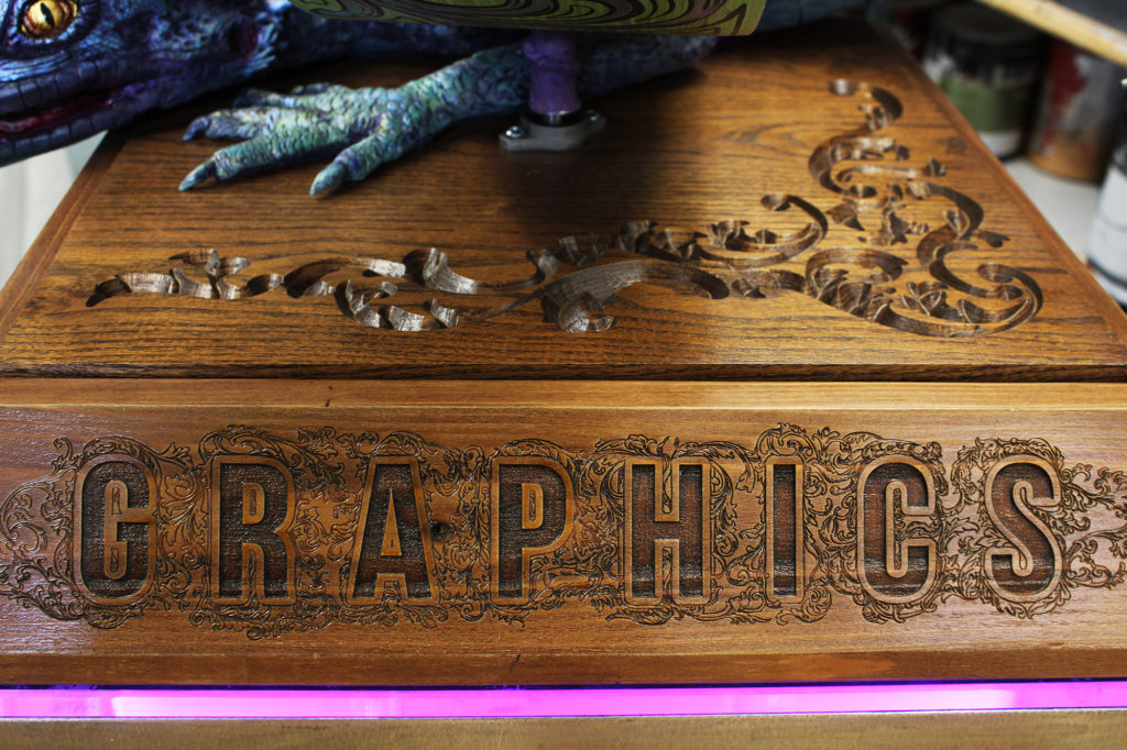wood with carved detail and laser engraved word "Graphics"