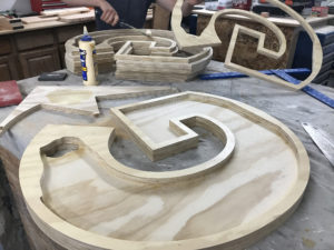 Person gluing plywood shapes together.