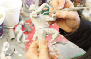 hand sculpting a figure
